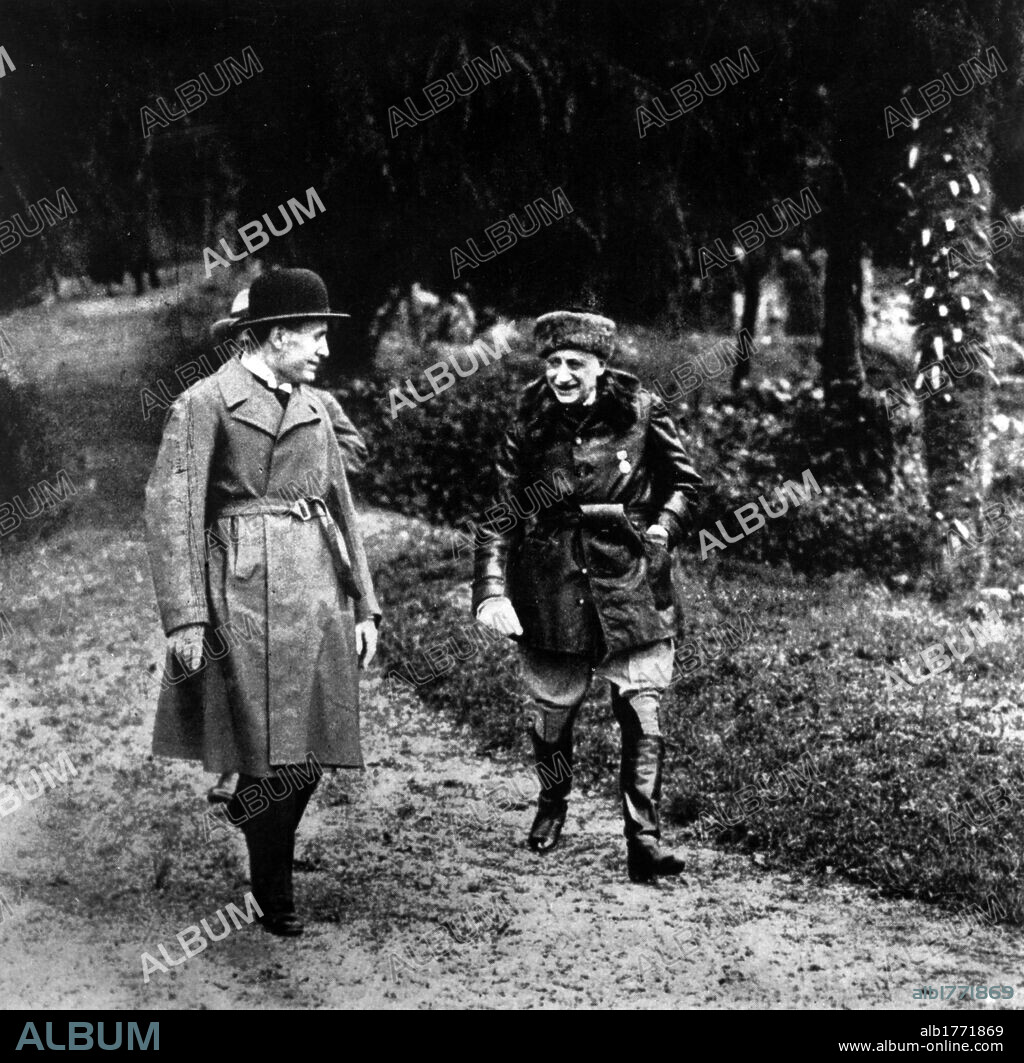 Gabriele D'Annunzio with Benito Mussolini. In the garden of Cargnacco Villa (the Vittoriale) Gabriele D'Annunzio, Italian poet and writer, walking with Benito Mussolini. Gardone Riviera, May 1925.