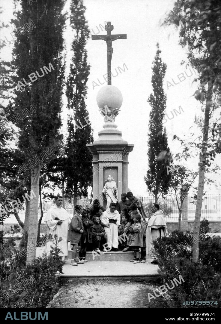 1930. Colonos de la escuela de reforma Escuchan lectura al aire libre en el jardín del reformatorio de Godella (Valencia).