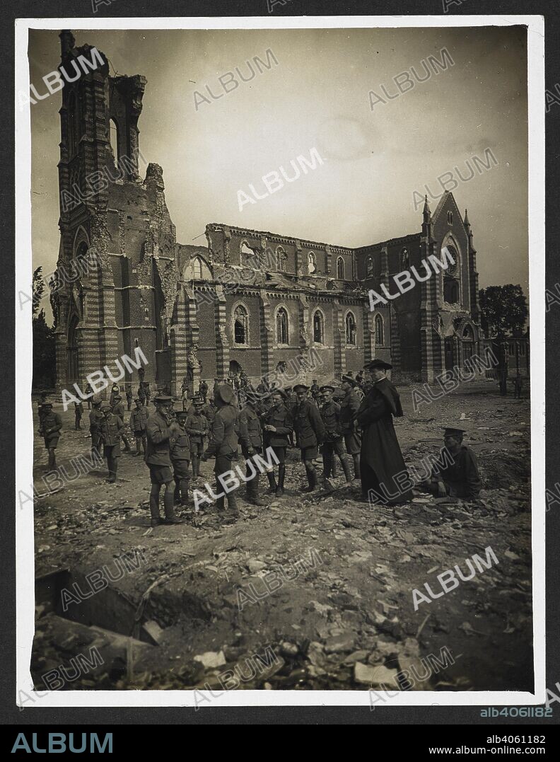 H. D GIRDWOOD. Church wrecked by German shells [Laventie, France]. British soldiers and a French priest gathered in the town square, with the ruined church in the background. 4 August 1915. Record of the Indian Army in Europe during the First World War. 20th century, 1915. Gelatin silver prints. Source: Photo 24/(226).