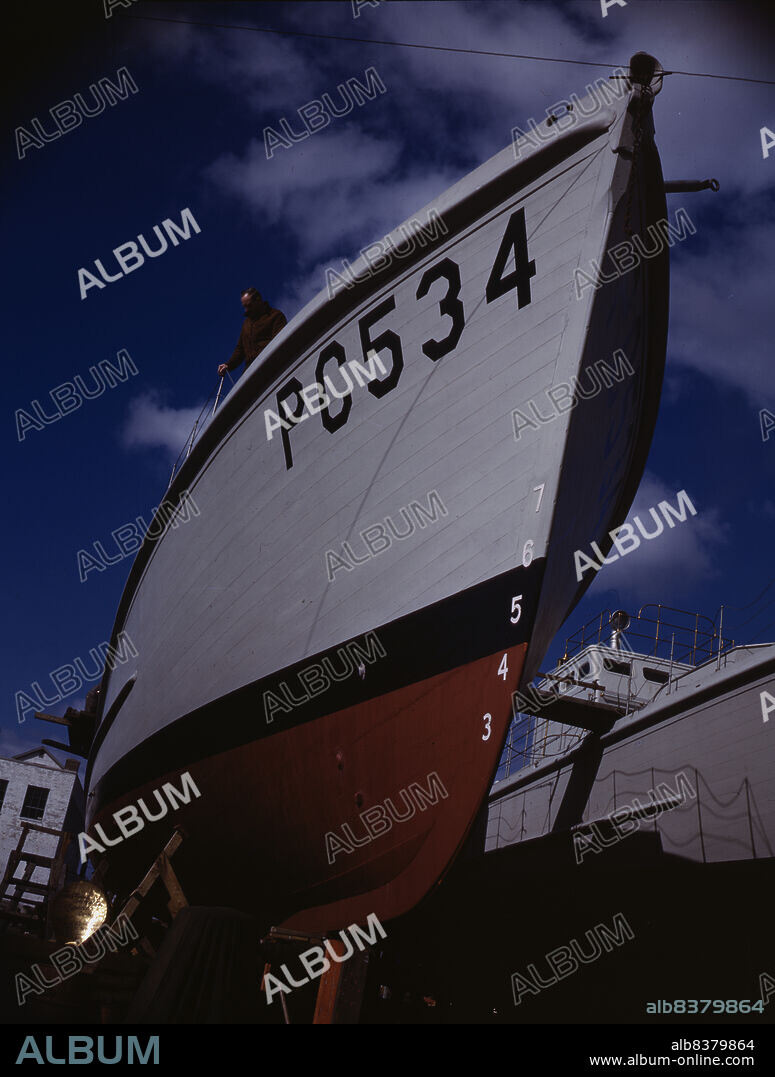 HOWARD LIBERMAN. Another harrier of the U-boats nears completion at an eastern boat yard, Marine Construction Co., Stamford, Conn. Many new 110-foot wooden sub-chasers are taking the water these days at yards in all parts of the country.
