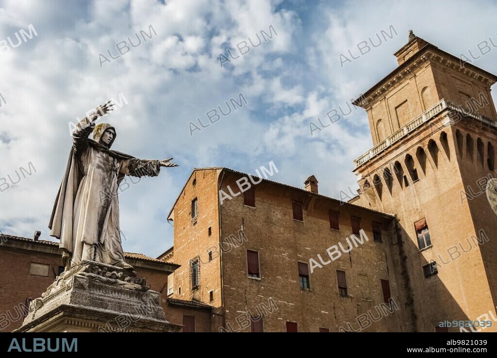 Monument and statue to Girolamo Savonarola, famous monk and reformer of Renaissance period, overlooking castle of Este family or Castello Estense in Ferrara, Italy