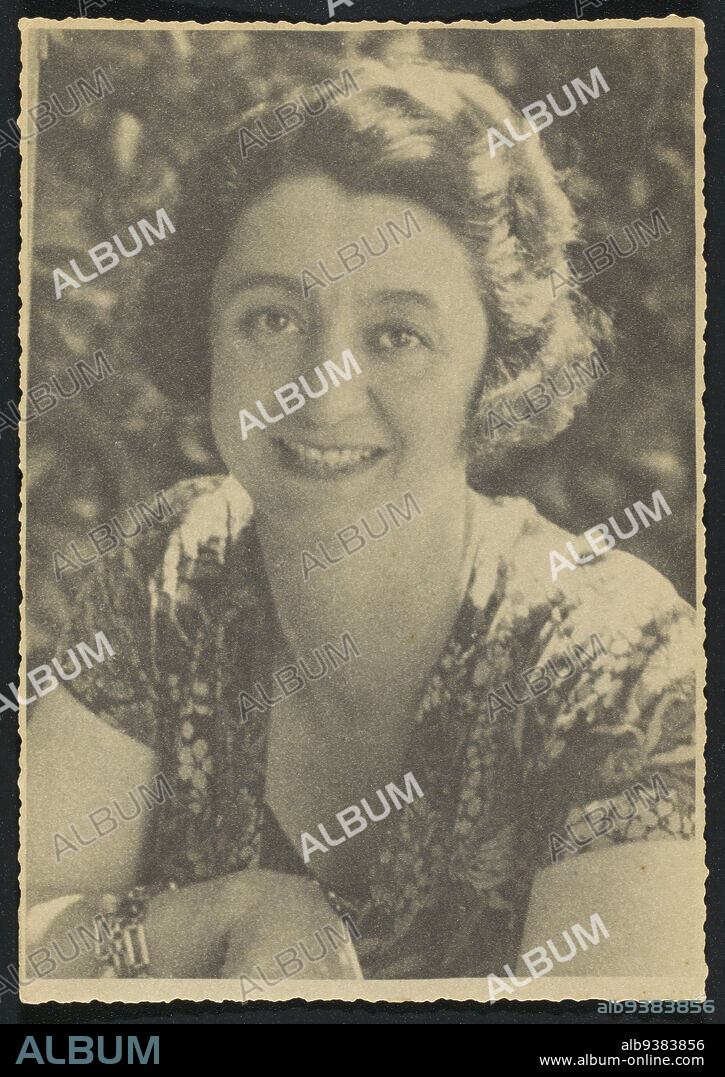 Portrait of Denise Vande Velde-Borgeaud, owner of closed fashion house in Brussels and London, Denise Vande Velde-Borgeaud looks straight into the camera and smiles. She has short wavy hair, combed back from the forehead. She is (presumably) wearing a floral gown with a deep V-neckline that shows a low-cut, plain dark shirt or blouse. Around her right forearm a number of bracelets: two with large rectangular links and one with round links., anonymous, Brussels (possibly), c. 1930 - c. 1936, paper, length 176 mm × width 123 cm.