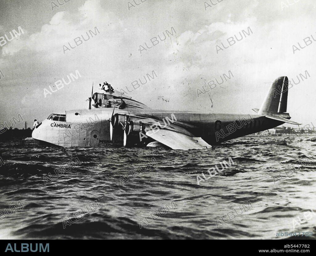 Imperial Airways Ship Crashes At Toronto - Members of the crew on the wing as the boat drifted to a stop. The Imperial Airways flying boat Cambria, which has successfully crossed the Atlantic Ocean three times, crashed in her landing at Toronto, Canada, September 3rd, when the gaint craft hit a floating landing, tearing a hole in one pontoon. The crew immediately took positions on the right wing, to counterbalance the damaged pontoon and save the craft from more serious disaster. September 5, 1937. (Photo by ACME).