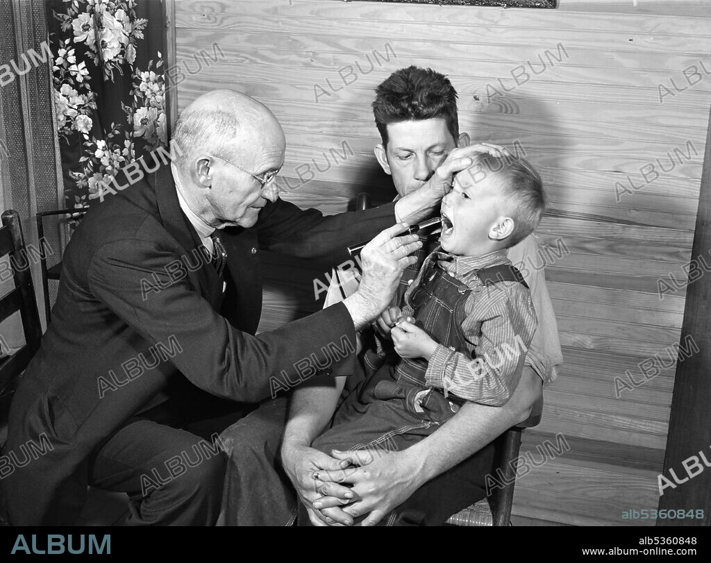 Doctor S.A. Malloy examining Mr. William H. Willis and his family, a Farm Security Administration (FSA) borrower, Blanch, North Carolina, USA, Marion Post Wolcott, U.S. Farm Security Administration, October 1940.