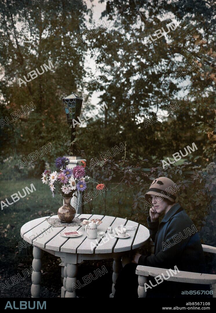 ARKIv 1930 . Färgfoto från uteservering på Djurgården i Stockholm.. Den första svenska färgbilden, ett kvinnoporträtt publicerades i Svensk Fototidskrift 1903. De första autochrome-plåtarna som användes till den här bilden kom till Sverige 1906 och fick en snabb spridning men det var först 1935-1936 med lanseringen av Kodachrome och Agfacolor-Neu-filmerna som förutsättningen för en bred utveckling skapades.. Denna bild är tagen 1930.. Colour picture from an outdoor café at Djurgården in Stockholm.. Foto: Ivar Ericson / Historical / kod 1900.