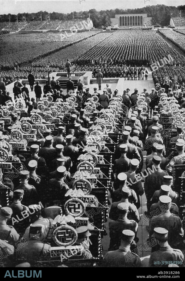 Adolf Hitler speaking at the Nuremberg Rally, Germany, 1935. Hitler (1889-1945) addressing the massed ranks of the party faithful at the 7th Congress of the Nazi Party.  A print from Adolf Hitler. Bilder aus dem Leben des Führers, Hamburg: Cigaretten/Bilderdienst Hamburg/Bahrenfeld, 1936.