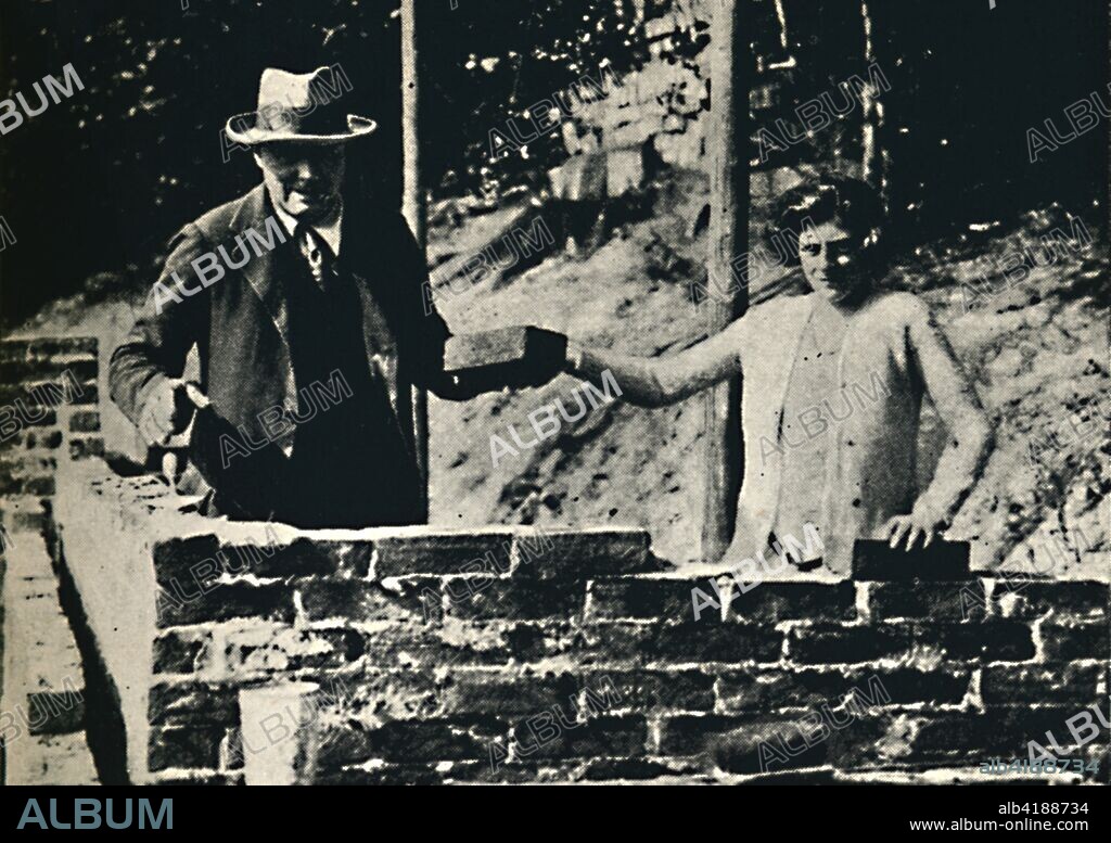 'Bricklayer and Artisan', 1928, (1945). British politician and statesman Sir Winston Churchill (1874-1965) laying bricks for the wall of a house on his estate at Westerham in Kent. His daughter Sarah (1914-1982) assists him. Churchill was Prime Minister of the United Kingdom from 1940 to 1945, and again from 1951 to 1955. From "The Life and Times of Winston Churchill", by Malcolm Thomson. [Odhams Press Limited, London].