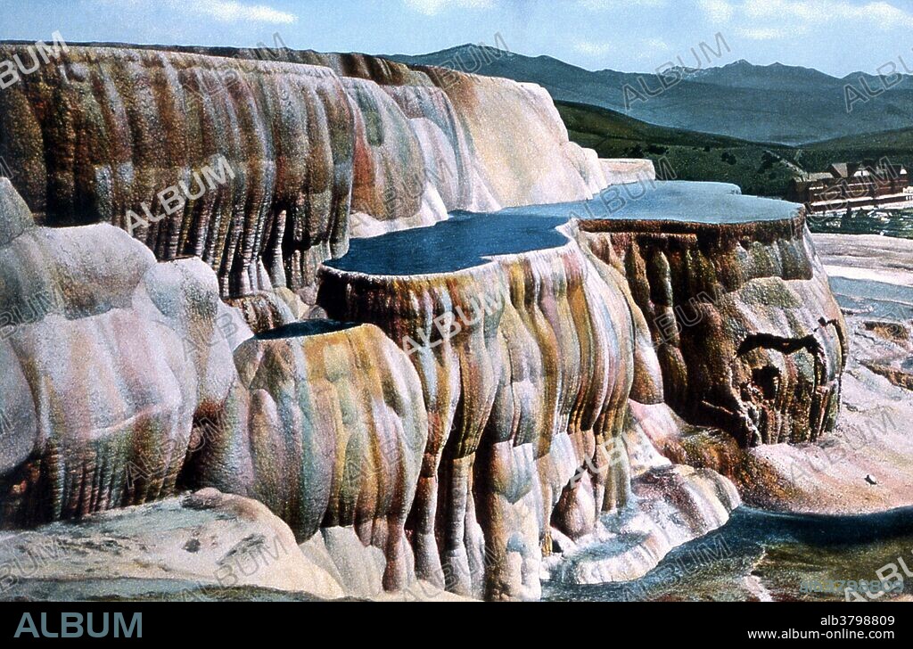Postcard of Mammoth Hot Springs photographed by Frank J. Haynes, no date. Mammoth Hot Springs is a large complex of hot springs on a hill of travertine in Yellowstone NP adjacent to Fort Yellowstone and the Mammoth Hot Springs Historic District. It was created over thousands of years as hot water from the spring cooled and deposited calcium carbonate (over two tons flow into Mammoth each day in a solution). Although these springs lie outside the caldera boundary, their energy has been attributed to the same magmatic system that fuels other Yellowstone geothermal areas. Yellowstone National Park is a national park located primarily in the state of Wyoming, although it also extends into Montana and Idaho. It was established by Congress and signed into law by President Ulysses S. Grant on March 1, 1872.