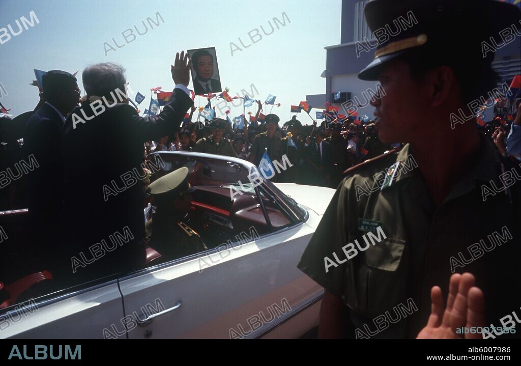 CAMBODIA Phnom Pehn Sihanouk and Hun Sen leave Pochentong airport in an open top car past waving crowds and soldiers.