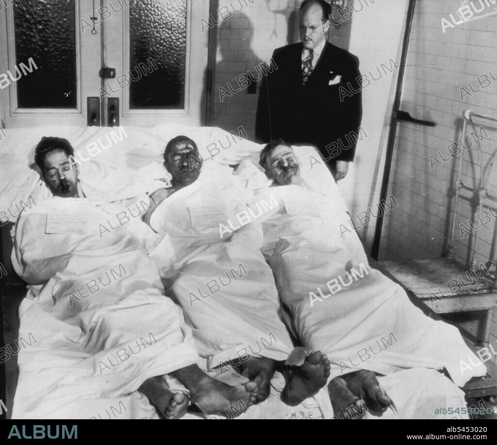 Slain Ringleaders Of Alcatraz Riot -- Bodies of three Alcatraz convicts, slain during the three days of rioting, in which they were ringleaders, lie in a morgue here late last night. Left to Right: Joseph Cretzer; Marvin Hubbard and Bernard Coy. James Leonard of Coroner's office looks down on them. May 05, 1946. (Photo by AP Wirephoto).