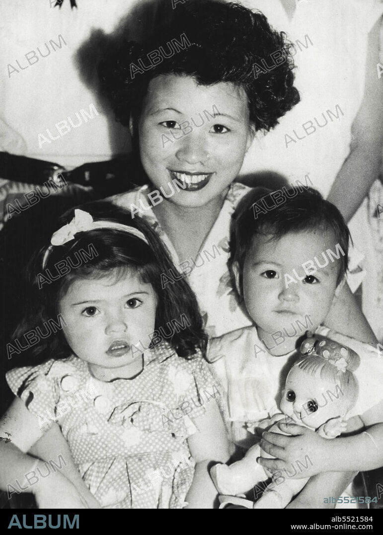 Pretty Japanese wife on board the New Australia, which berthed in Brisbane today, was Mrs. S. Franklin, whose husband is a sergeant with the 1st Battalion. Here she is nursing Eileen Perkins, 2 years, and her own daughter, Margaret, also 2. April 06, 1953.