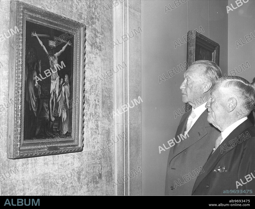 West German Chancellor Konrad Adenauer and Chester Dale of New York look at a painting titled "The Small Crucifixion" by German artist Mathis Grunewald. April 1961.