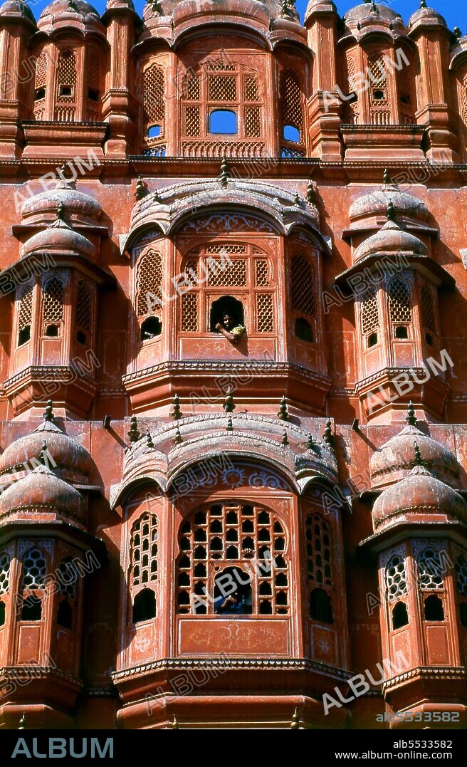 The Hawa Mahal was built in 1799 by Maharaja Sawai Pratap Singh, and designed by Lal Chand Ustad in the form of the crown of Krishna, the Hindu god. Jaipur is the capital and largest city of the Indian state of Rajasthan. It was founded on 18 November 1727 by Maharaja Sawai Jai Singh II, the ruler of Amber, after whom the city was named. The city today has a population of 3.1 million. Jaipur is known as the Pink City of India. The city is remarkable among pre-modern Indian cities for the width and regularity of its streets which are laid out into six sectors separated by broad streets 34 m (111 ft) wide. The urban quarters are further divided by networks of gridded streets. Five quarters wrap around the east, south, and west sides of a central palace quarter, with a sixth quarter immediately to the east. The Palace quarter encloses the sprawling Hawa Mahal palace complex, formal gardens, and a small lake. Nahargarh Fort, which was the residence of the King Sawai Jai Singh II, crowns the hill in the northwest corner of the old city. The observatory, Jantar Mantar, is a World Heritage Site.