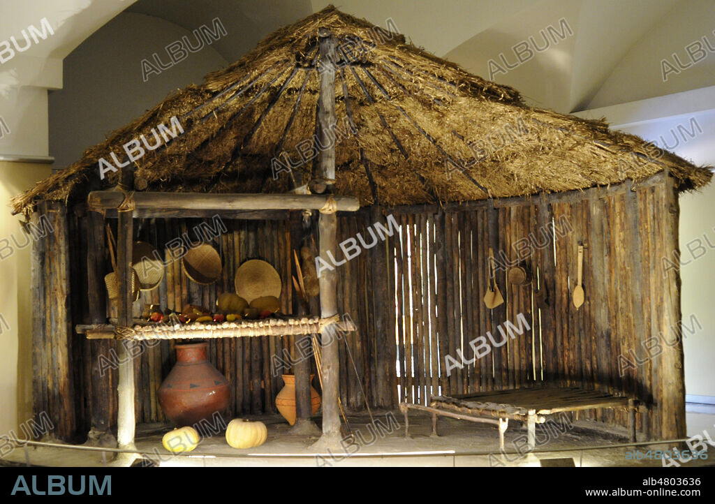 Región amazónica. La casa de los jíbaros (Shuar). Casa circular aislada. Representación del cosmos. Permite al que habita orientarse dentro del universo. La viga que sostiene la casa simboliza la unión de la tierra y el cielo. Museo de América. Madrid. España.