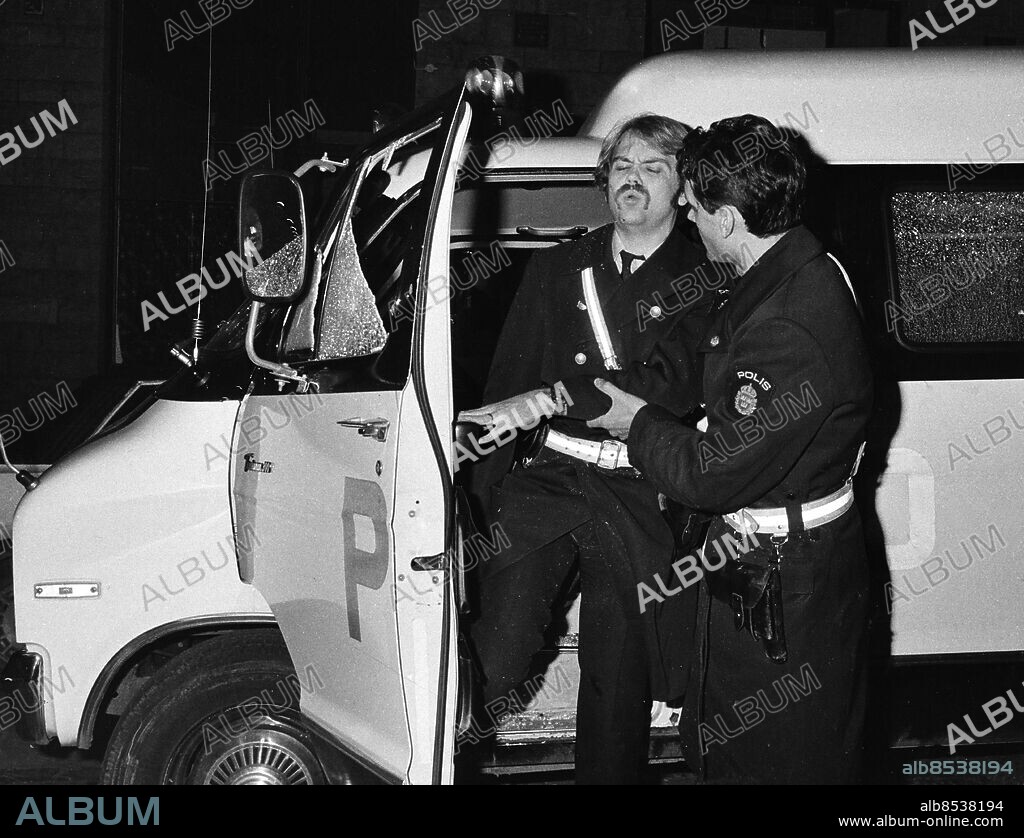 ARKIV STOCKHOLM 19791123. Den skottskade polisen får hjälp av tillskyndande kolleger. Lars-Inge Svartenbrandt och Benny Lilja rånade posten på Döbelnsgatan i Stockholm, under flykten sköt Svartenbrandt med automatvapen rakt in i polisbussen.. Foto: Ulf Blumenberg/DN/SCANPIX Kod: 192. ** SVD OUT **.