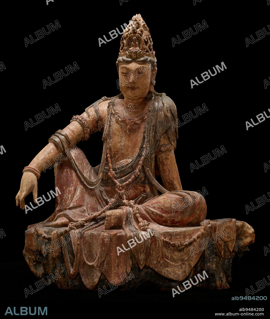 Avalokiteshvara Bodhisattva in the Water-Moon Form (Shuiyue Guanyin), 12th century, 40 1/2 x 33 1/2 x 20in. (102.9 x 85.1 x 50.8cm), Wood, gesso and pigments, China, 12th century, Of the many manifestations of the bodhisattva Avalokiteshvara, perhaps none was more prevalent in East Asia than the uniquely Chinese form known as 'Water-Moon Avalokiteshvara,' which later also spread to Korea and Japan. This form of the bodhisattva presides over his own paradise, Potolaka, which is described in scripture as a rugged seaside cave from which Avalokiteshvara could admire the reflection of the moon in the water. Appropriately, he appears meditative and relaxed and is seated informally in the 'royal-ease' posture. Ornately dressed, with silk robes, fluttering sashes, jewelry, and an elaborate hairstyle, he also wears a headpiece that features an image of Amitbha, the buddha to whom Avalokiteshvara attends. Believers might look to a sculpture like this as a guide for their own journeys toward enlightenment.