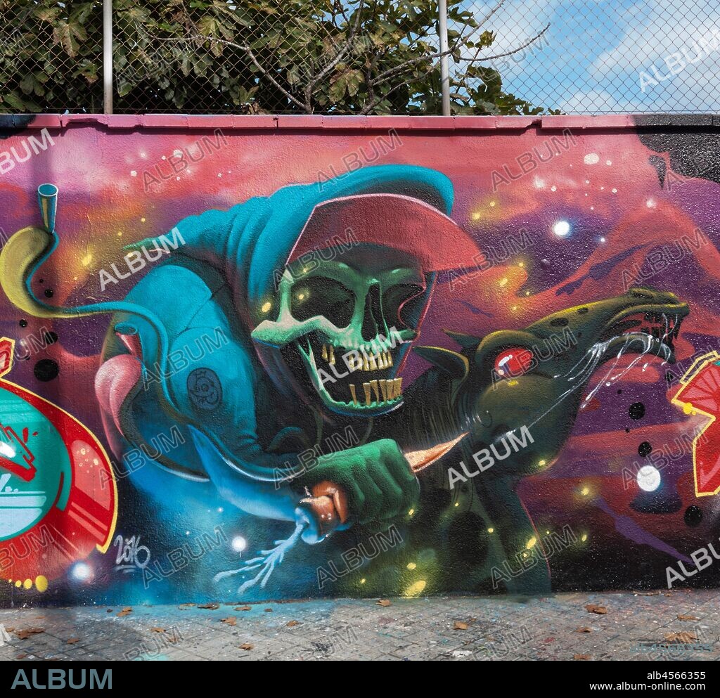 Pintura estilo cómic de calavera con visera y capucha con una zanahoria en la mano, graffiti mural, calle Agricultura, Poblenou, Distrito San Martin, Barcelona en 2016.