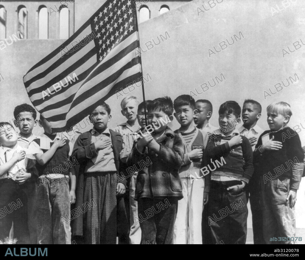 San Francisco, California, April 1942. Children at the Weill public school for the so-called international settlement and including many Japanese-Americans, saluting the flag. They include evacuees of Japanese descent who will be housed in War relocation authority centres for the duration.