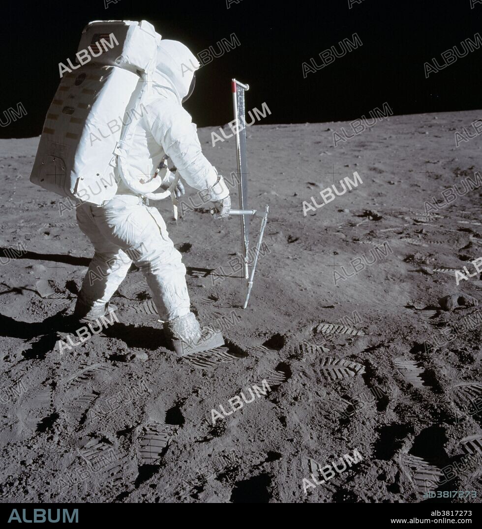 Astronaut Edwin E. Aldrin Jr., lunar module pilot, is photographed during the Apollo 11 extravehicular activity (EVA) on the moon. He is driving one of two core tubes into the lunar soil. Astronaut Neil A. Armstrong, commander, took this picture with a 70mm lunar surface camera. Aldrin stands near the Solar Wind Composition (SWC) experiment, a component of the Early Apollo Scientific Experiments Package (EASEP, deployed earlier). The SWC is in the center background.