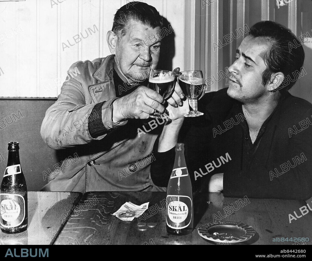 Stockholm 1965-10-14. Skål och puttäll på er! Stamkunderna på Café Uven i Stockholm Anders Eriksson och Boris Blomberg provade det nya mellanölet redan strax efter klockan 5 i morse. Mottagandet: gott, men knappast entusiastiskt. Mellanölet blir för dyrt två kronor med dricks.. Man får väl äta mindre, sa gubbarna.. Foto: Olle Wester / Expressen / TT / Kod: 44. ** AFTONBLADET OUT **.