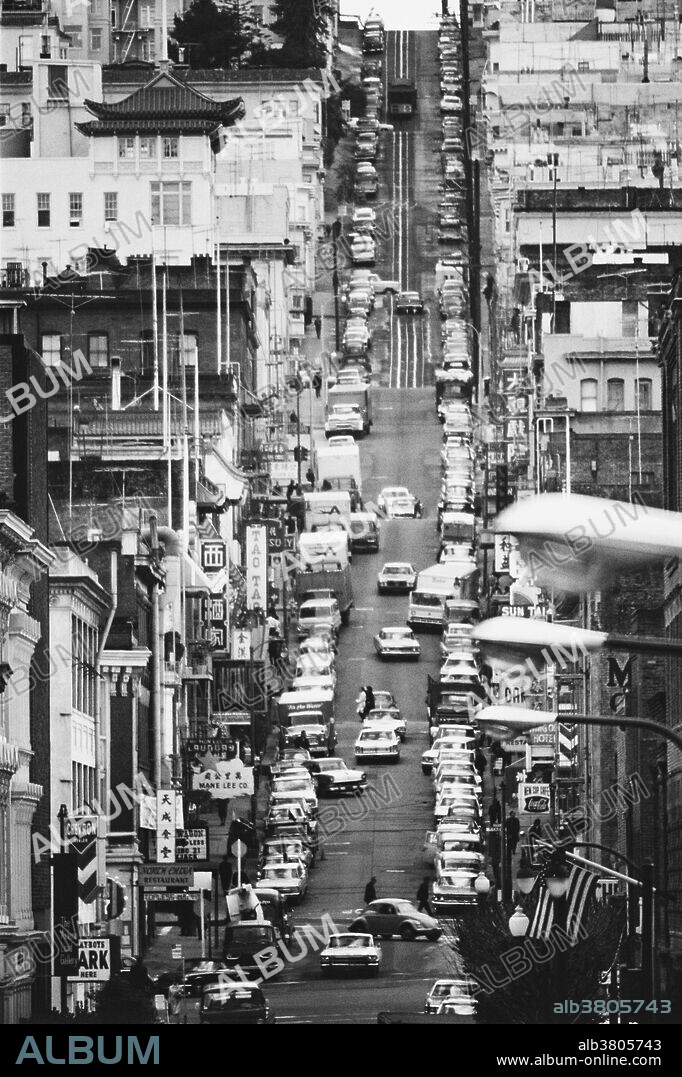 View of a street in San Francisco's Chinatown, showing cable car, 1960s.