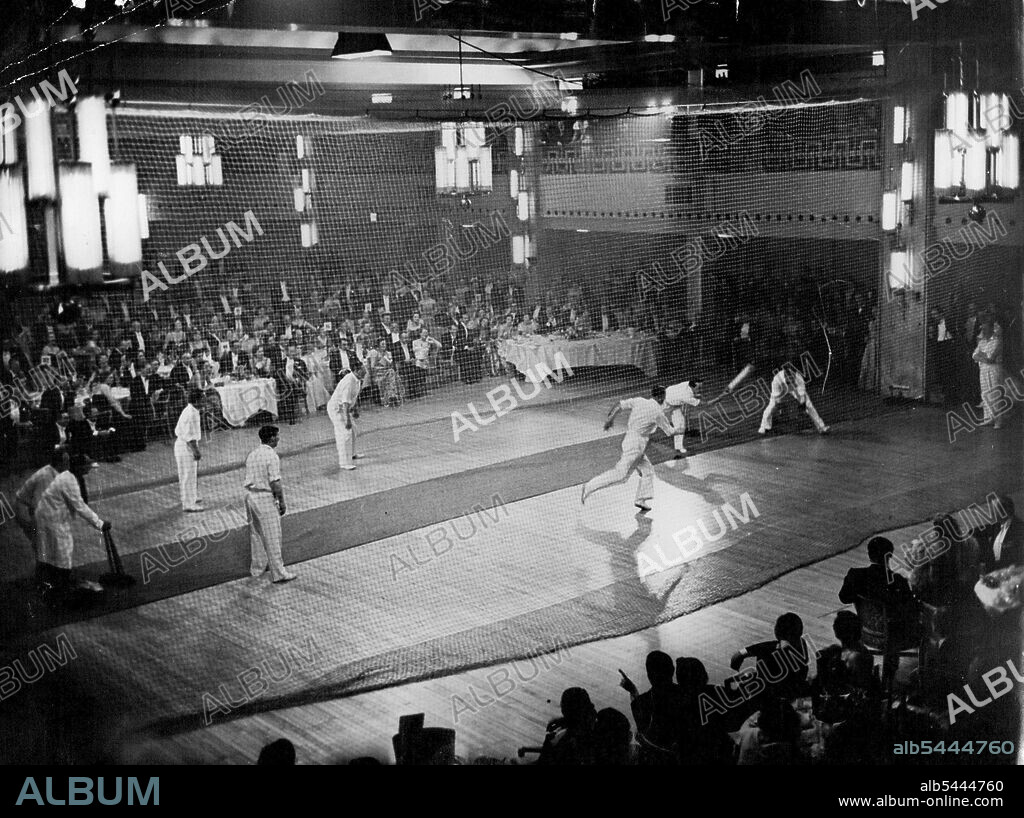 Ballroom Cricket. Bill Edrich sweeps a ball to leg in a cricket match played in the ballroom of Grosvenor House during the Lord's Taverners' Ball. The Lord's Taverners are an association of cricket spectators of which the Duke of Edinburgh is President. Princess Elizabeth and the Duke attended the ball. May 12, 1951. (Photo by The Associated Press Ltd.).