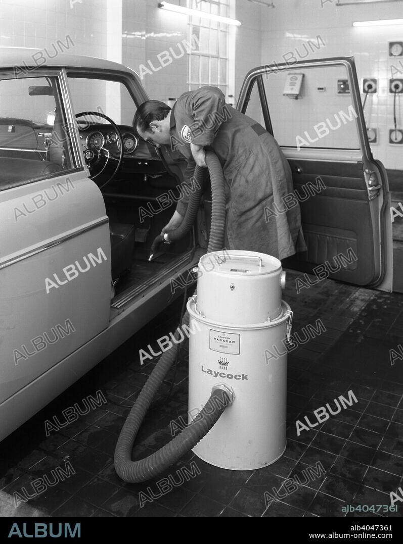 Laycock Vacacar vacuum cleaner in use at an Esso garage, Sheffield, South Yorkshire, 1965. In addition to their wide range of vehicle lifts and testing equipment from their base in Sheffield, Laycock engineering produced this Vacacar Vacuum cleaner for the commercial valeting of car interiors. The photograph shows the cleaner in use being used on an Austin Westminster of 1962 vintage by an employee of an Esso Garage in Sheffield. April 1965.