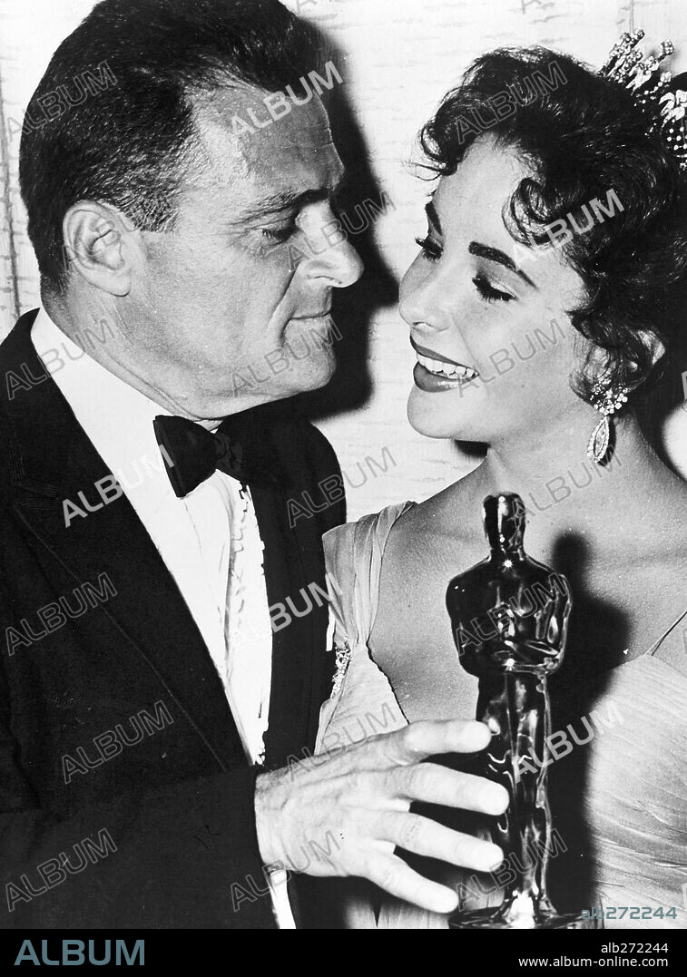 ELIZABETH TAYLOR y MIKE TODD. 29ª Edición de los Premios Oscar (1957). El productor Mike Todd con el premio a la mejor película "La vuelta al mundo en 80 días". Le acompaña su esposa y actriz Elisabeth Taylor. 1957
