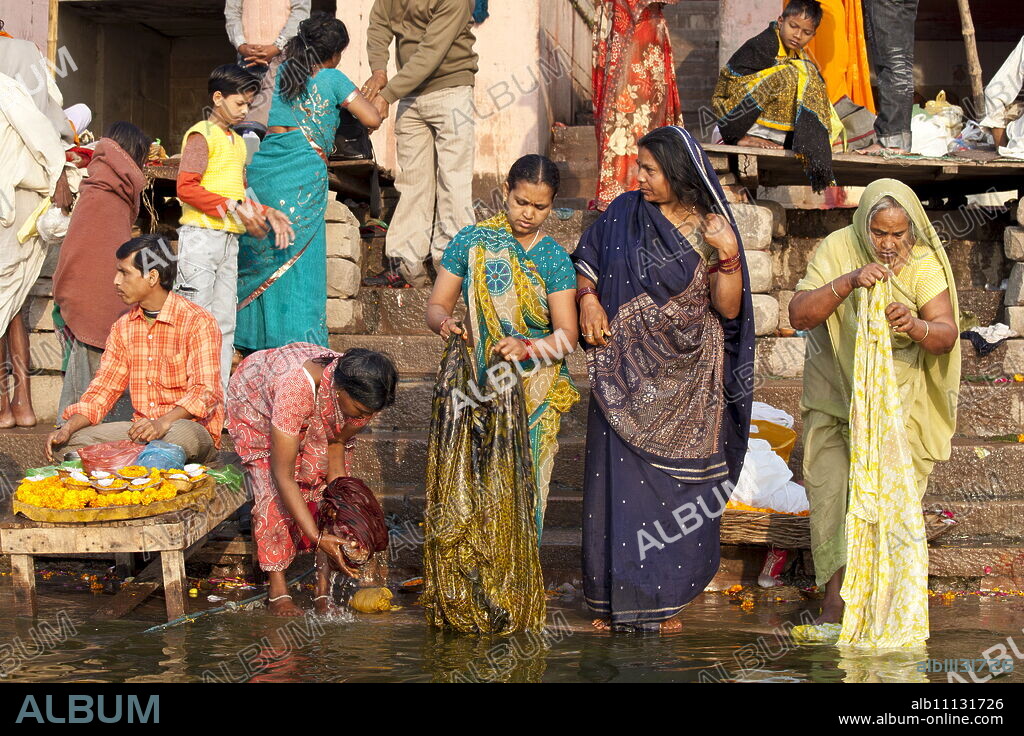 Indian Hindu pilgrims bathing in The Ganges River at Dashashwamedh Ghat in Holy City of Varanasi, Benares, India.