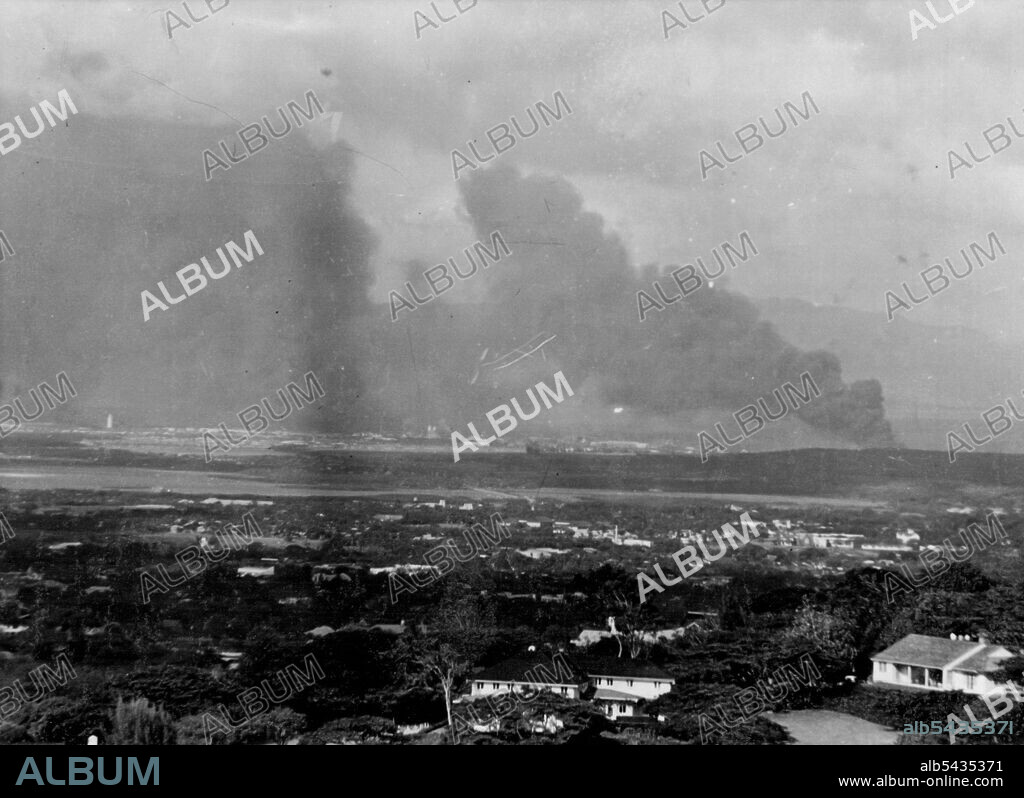 Pearl Harbor Burns After Surprise Attack -- Pearl Harbor, U.S. military and naval stronghold in the Pacific, lies under an ominous pall of black smoke December 7 shortly after Japanese planes bombed the Harbor and surrounding military objectives while Japan's "Peace Negotiators" still talked of peace to Secretary Hull in Washington and the United States Ambassador to Japan was being told in Tokyo that Nipon desired peace. The photo was made from Mt. Tantalus, behind Honolulu. December 16, 1941.