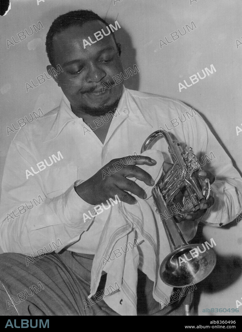 Polished. World-famous negro trumpeter, Rex Stewart, applies a little "spit and polish" in preparation for the Miss Australia variety concert at the Sydney Town Hall tomorrow night to aid the RSL War Neurosis Fund. November 29, 1949.