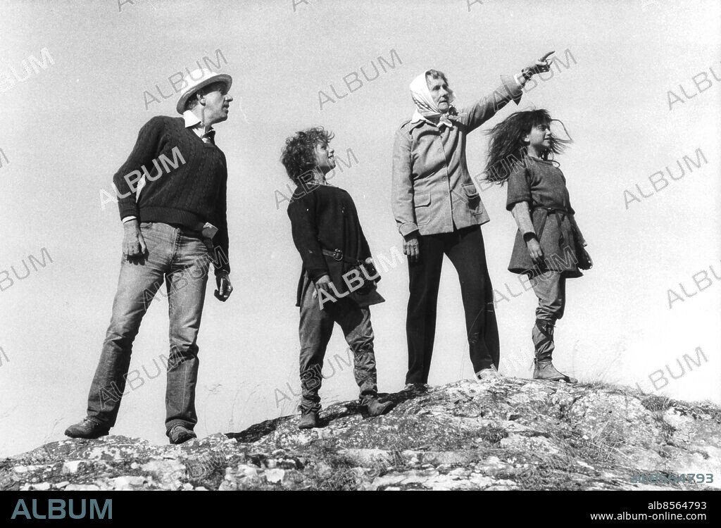 ©SCANPIX SWEDEN, 1983.. Inspelning av filmen -Ronja Rövardotter-.. Astrid Lindgren och Tage Danielsson med skådespelarna Hanna Zetterberg som spelar Ronja och Dan Håfström som spelar Birk. Astrid Lindgren pekar, de andra ser uppåt himlen. De står på en klippa.. Foto: NTB. Code: 30230.