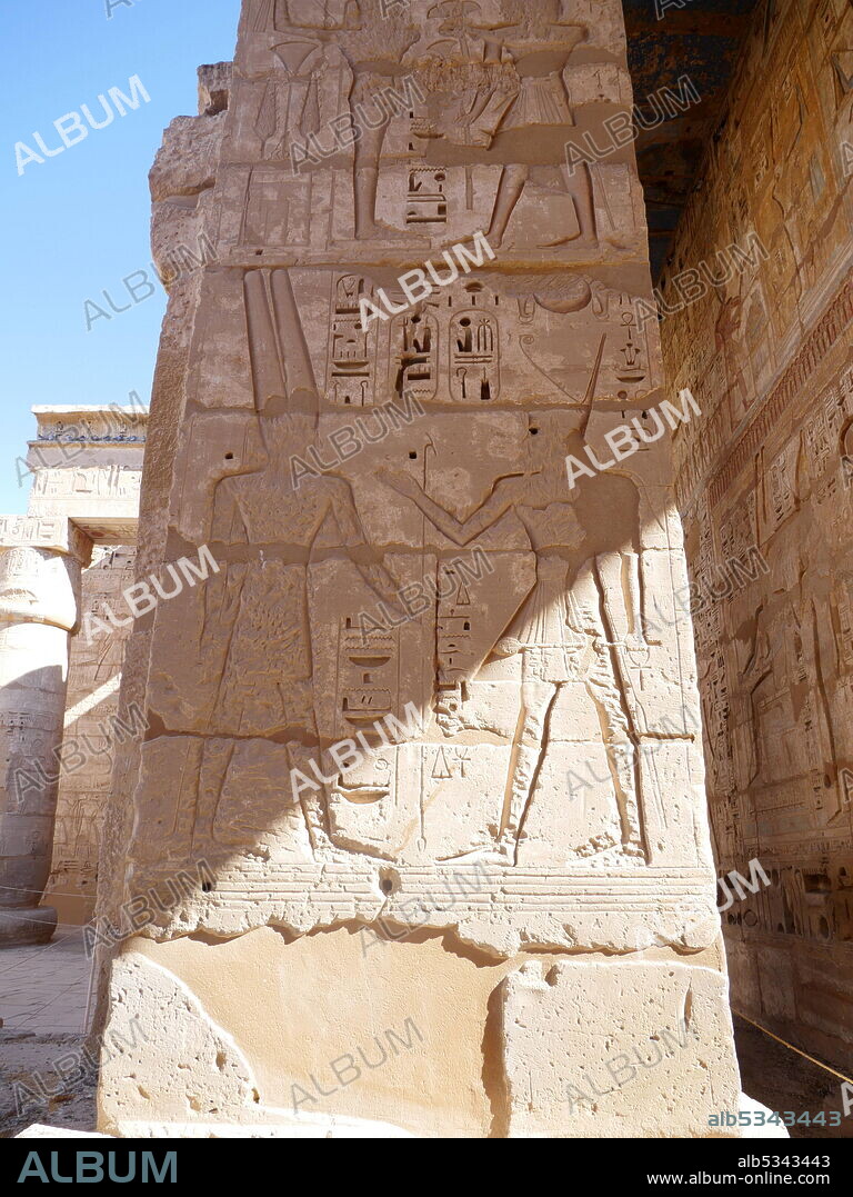 Mortuary Temple of Ramesses III at the Temple of Amun, (Djeser Set) dating to the 18th Dynasty. Built by Hatshepsut and Thutmose III. Part of the Mortuary Temple of Ramesses III at Medinet Habu. New Kingdom period structure in the West Bank of Luxor in Egypt. Aside from its size and architectural and artistic importance, the temple is probably best known as the source of inscribed reliefs depicting the advent and defeat of the Sea Peoples during the reign of Ramesses III. The temple, some 150 m long, is of orthodox design, and resembles closely the nearby mortuary temple of Ramesses II (the Ramasseum). The temple precinct measures approximately 210 m (690 ft). by 300 m (1,000 ft) and contains more than 7,000 m2 (75,347 sq ft) of decorated wall reliefs..