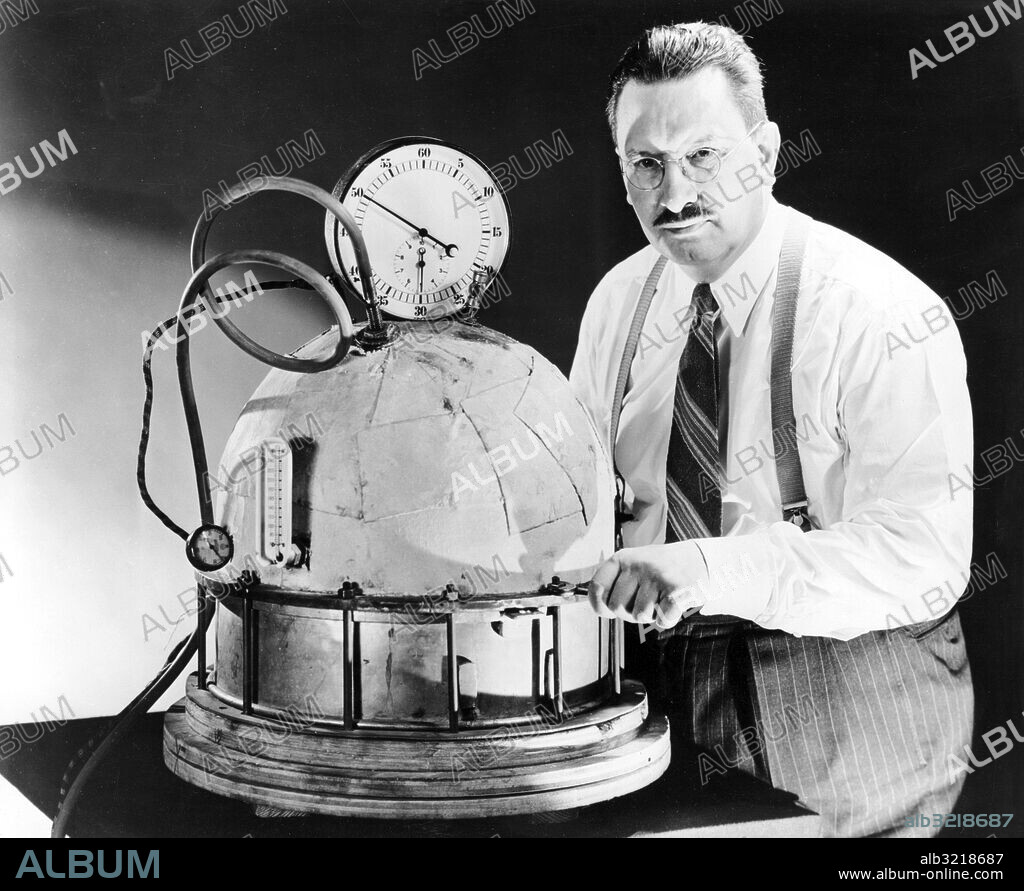 Orig. bildtext... WE'LL BE SITTIN' PRETTY! PLASTIC PRESSURE COOKER - Egmont Arens, designer of the new curved chair is shown here with his home-made plastic pressure-cooker, an apparatus set up in his New York laboratory to test his theory that plastics, reinforced with some kind of fibre would be strong enough for making large area contour moldings. Anm. Mätare Tryckmätare Hembyggen CD40 persons: Egmont Arens sites: USA ;NEW YORK.