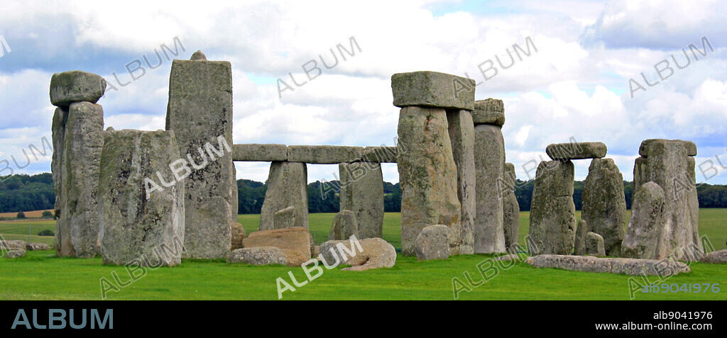 Stonehenge is a prehistoric monument located in the English county of Wiltshire, one of the most famous sites in the world. It is composed of earthworks surrounding a circular setting of large standing stones. It is the centre of the most dense complex of Neolithic and Bronze Age monuments in England, including several hundred burial mounts.