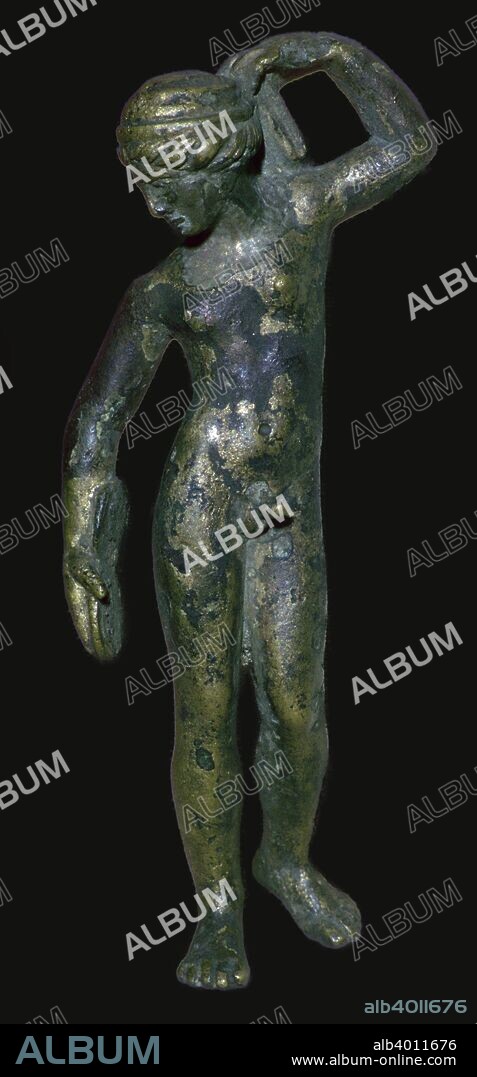 Roman copper alloy figure of a nude male wearing a turban with wavy hair beneath. In his right hand he holds an object which might be a jumping weight or a folding mirror, so he might represent an athlete or Narcissus. However the small breasts have been interpreted as indicating that he represents a hermaphrodite. Found in the River Thames. From the British Museum's collection.