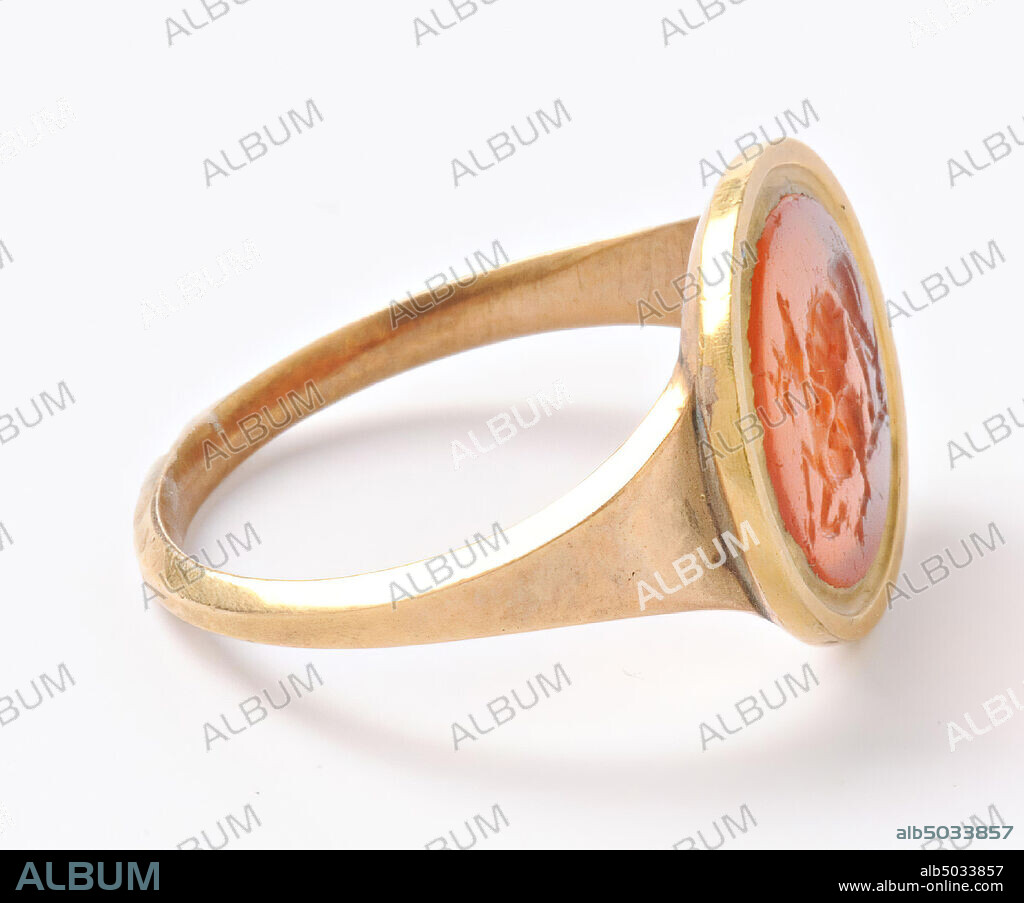 Vz: a large lion stands on the right hind leg of a fallen deer, whose legs are bent and the head is still upright, the lion tears the neck, gem, intaglio, ringstone, carnelian, to the right, Color: orange-red, Shape: oval, Processing: in modern golden ring, Method: soft modeling with rounded drills, detailing with several wheel grooves and binderolle pellets., 13 x 11 mm, D. 2.5 mm, end of the 1st century v. Chr. -25.