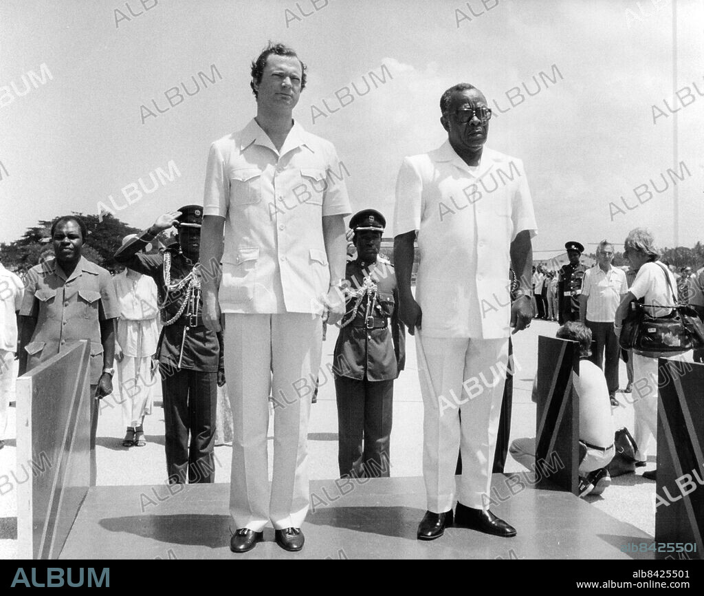 Zanzibar 1981-02-01. Kung Carl XVI Gustaf iklädd vit safariuniform tillsammans med lokala politiker under statsbesöket i Tanzania. Drottning Silvia i bakgrunden. Foto: Leif R Jansson / Svenskt Pressfoto / TT / kod 20360.