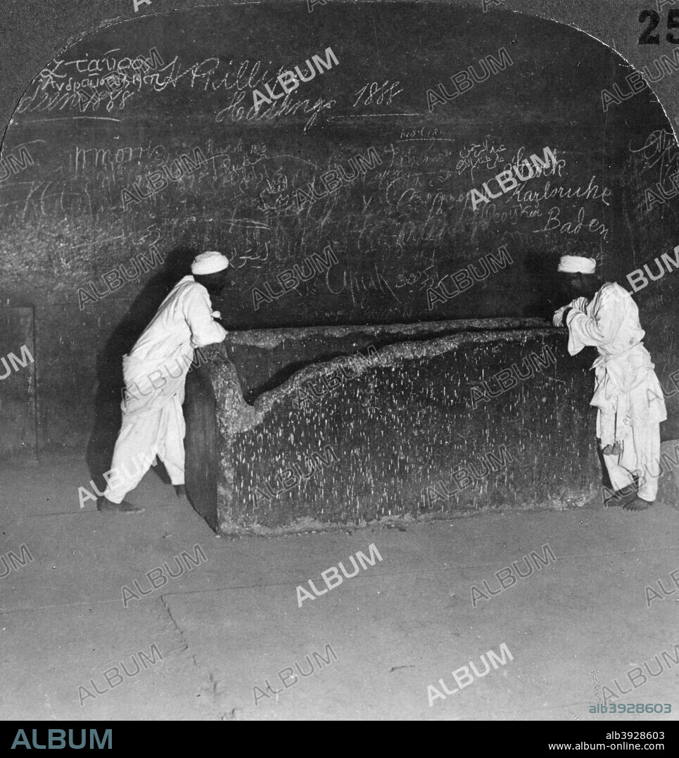 'Khufu's sarcophagus, broken by robbers, in the Great Pyramid, Egypt', 1905. 'See how the tomb-robbers have broken away the corner in their mad search for treasure. There his body was torn from its resting-place and plundered of its rich regalia and splendid jewellery, then left in dishonour and confusion among fragments of stone and tattered mummy-cloth lying upon the floor.' Stereoscopic card. Detail. From a series called Egypt Through the Stereoscope, text by James H Breasted.