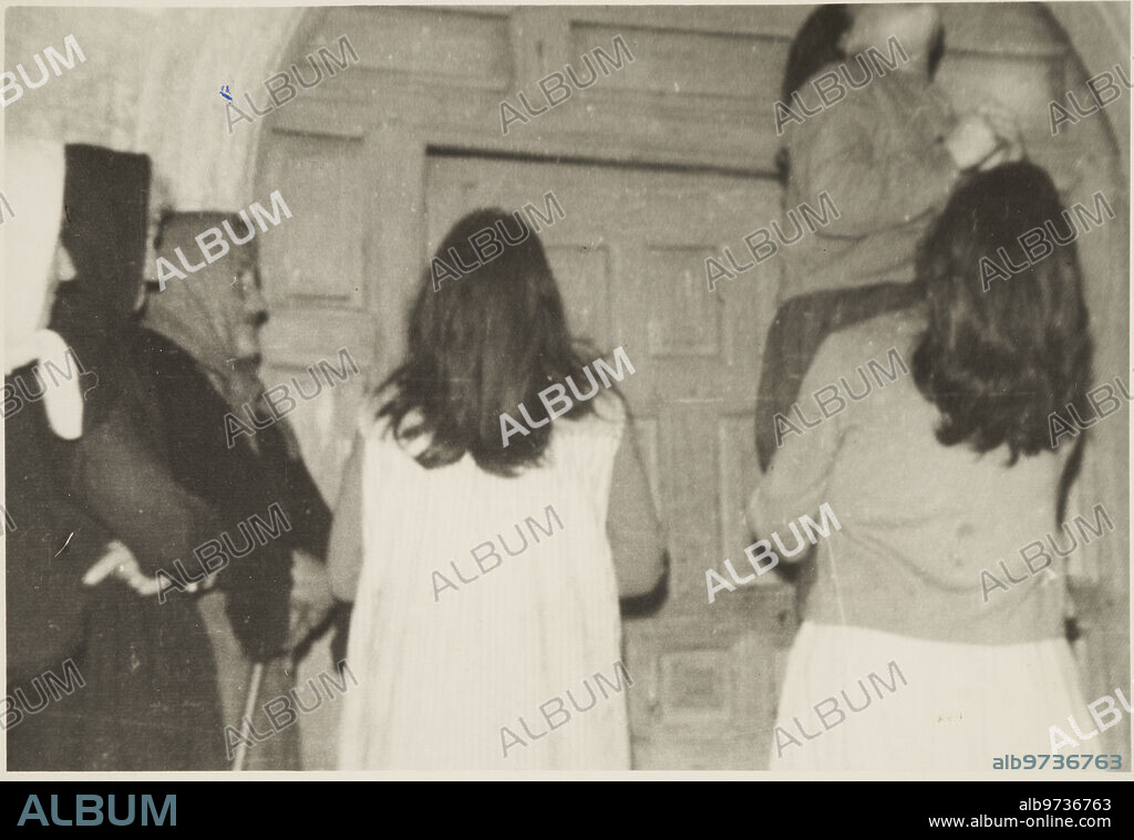 San Sebastián de Garabandal (Cantabria), 1965. Mystery of the apparitions of the Virgin and the angel Saint Michael. In the image, Conchita lifts Mari Loli, without any effort, so that she can kiss the face of the apparition at the door of the church.