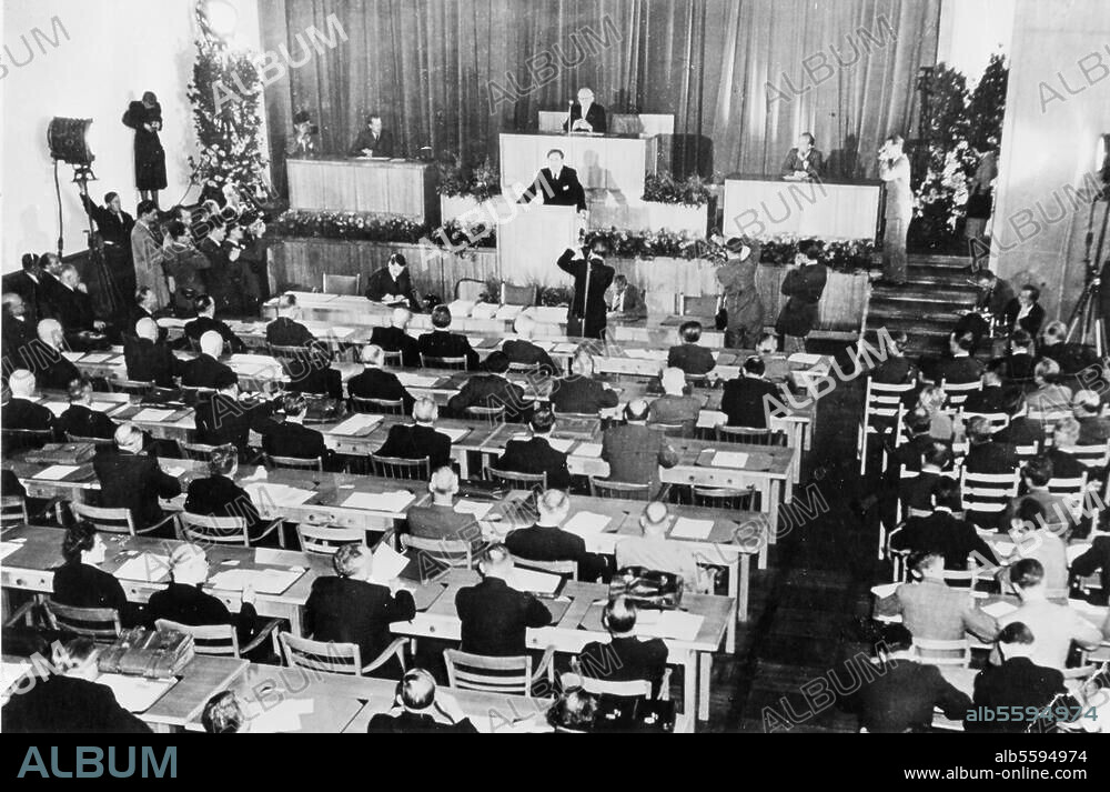 Parlamentarischer Rat 1948/49 (Verfassungsgebende Versammlung zur Ausarbeitung des Grundgesetzes) / Konstituierende Sitzung am 1. September 1948. Am Präsidentenpult der Alterspräsident Dr. Adolph Schönfelder; am Rednerpult der Vorsitzende der SPD Südwest-Baden, Prof. Dr. Carlo Schmid. Foto.