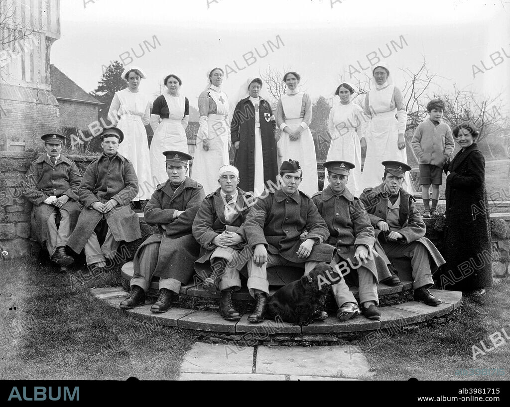 Convalescent soldiers and nursing staff outside Nathaniel Lloyd's house with Nathaniel Lloyd's family, Great Dixter, East Sussex, 1916. The family home of the author and photographer Nathaniel Lloyd was used as a military hospital during the First World War 1914-1918.