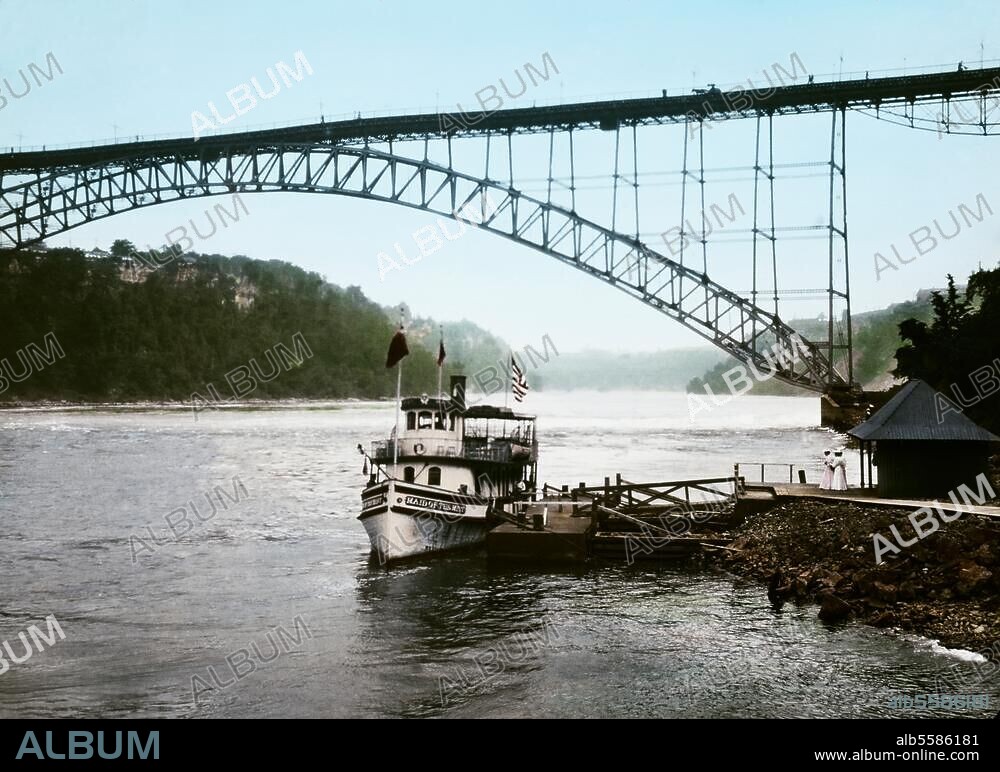 New York (USA), Hudson River. Ausflugsdampfer unter einer Stahl-Bogenbrücke auf dem Hudson River bei New York. Foto, koloriert, 1905 (Waldemar Abegg).