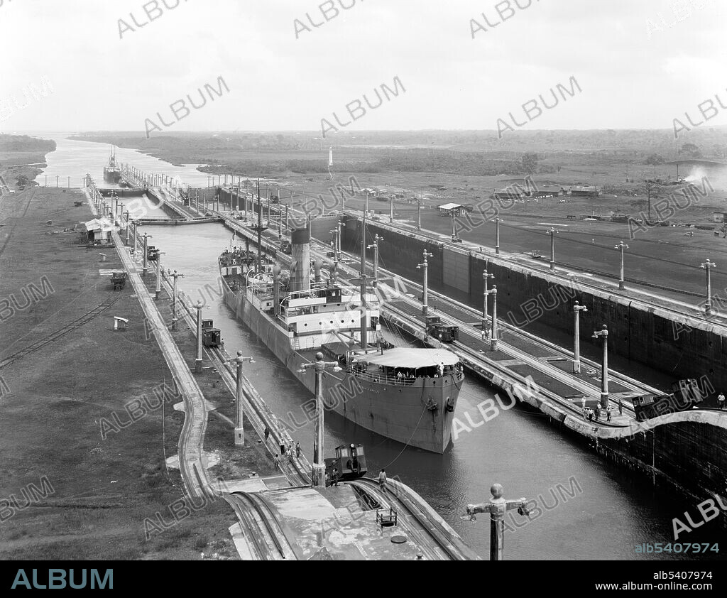 Gatun Lock, west chamber, Panama Canal, between 1910 and 1920. The Panama Canal is an artificial 82 km (51 mi) waterway in Panama that connects the Atlantic Ocean with the Pacific Ocean. The canal cuts across the Isthmus of Panama and is a conduit for maritime trade. Canal locks are at each end to lift ships up to Gatun Lake, an artificial lake created to reduce the amount of excavation work required for the canal, 26 m (85 ft) above sea level, and then lower the ships at the other end. France began work on the canal in 1881, but stopped due to engineering problems and a high worker mortality rate. The United States took over the project in 1904 and opened the canal on August 15, 1914.