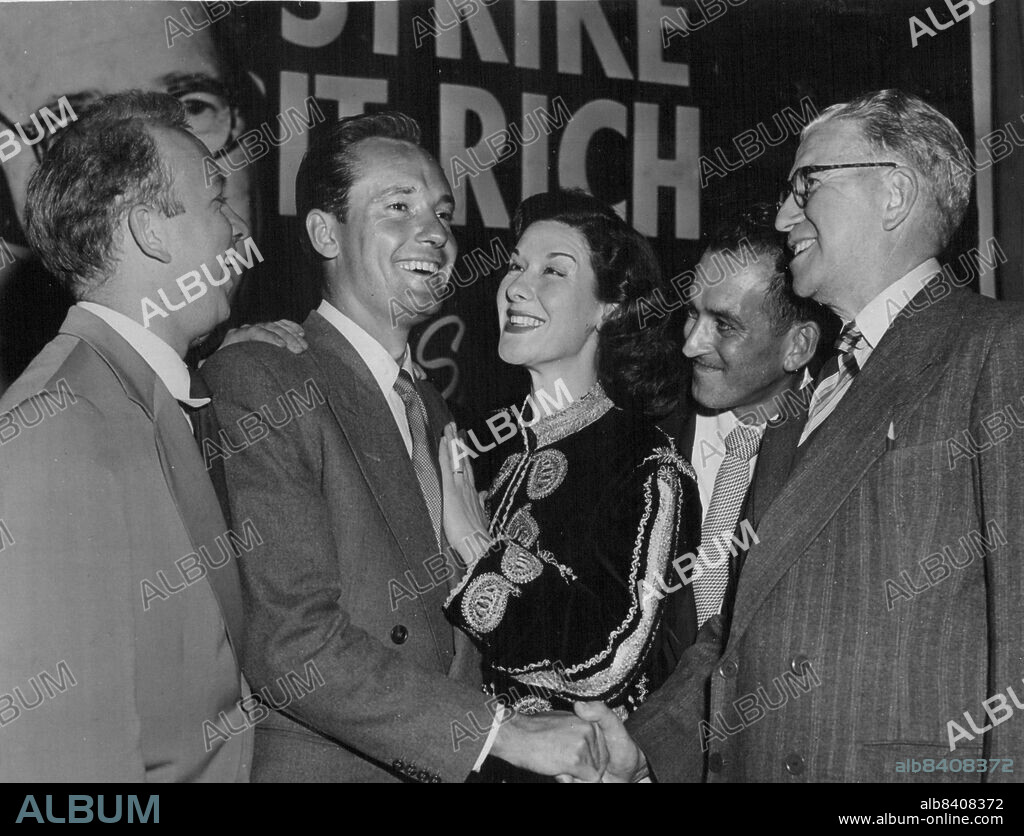 Charles Tingwell Australian film and radio actor, being congratulated last night by Margaret Christensen on securing a role in the 20th Century-Fox production Desert Rats. He received a cable just before he went on the air in the Strike it Rich program. November 6, 1952. (Photo by Scott Polkinghorne).