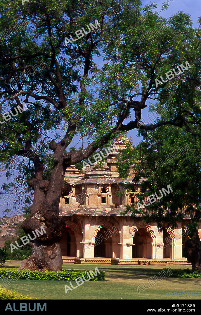 The Lotus Mahal is a construction of the later Vijayanagara period and shows Islamic influence in its arched gateways and vaulted ceilings. The Zenana Enclosure is a walled compound that originally housed the women of the royal household. Hampi is a village in northern Karnataka state. It is located within the ruins of Vijayanagara, the former capital of the Vijayanagara Empire. Predating the city of Vijayanagara, it continues to be an important religious centre, housing the Virupaksha Temple, as well as several other monuments belonging to the old city.