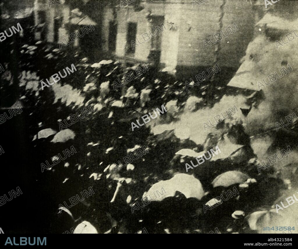 A bomb explodes on the day of the wedding of King Alfonso XIII and Victoria Eugenie of Spain, Madrid, 31 May 1906, (1910). 'The most remarkable Press picture ever obtained - The actual exploding of the bomb thrown at the King and Queen of Spain'. Librarian Mateu Morral threw a bomb hidden in a flower bouquet from his hotel window as the royal procession passed. Alfonso XIII and Victoria Eugenie were unhurt in the assassination attempt, but 24 bystanders and soldiers were killed and over 100 others were injured. When Morral was discovered two days later he shot a police officer and killed himself. The attempted regicide became known as The Morral Affair. From "The Strand Magazine, an illustrated monthly", Volume XL - July to December 1910. [George Newnes Ltd, London, 1910].