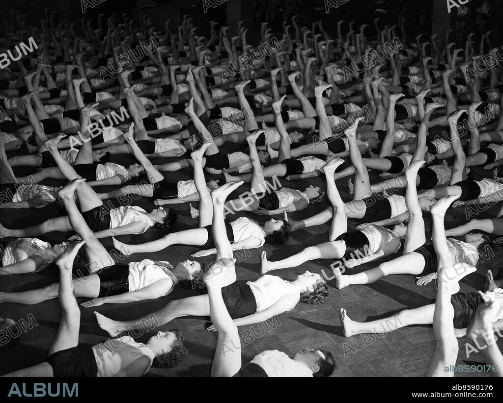 STORBRITANNIEN LONDON 1947-10-25. Orig. bildtext... LEAGUE OF HEALTH AND BEAUTY OPENS AUTUMN SEASON. The Women's League of Health and beauty, under its Director, Lady David Douglas-Mailton (Prunella Stack), opened its autumn season with a mass reunion class at the New hall of the Royal Horticultural Society, Vincent-square, S.W.1., this afternoon (Saturday). members of the League from all parts of the country were there to participate in the exercises. Photo shows: All up together! Some of the 900 participants in this afternoon's mass reunion class point their legs to the ceiling. Foto: Reuterphoto / AB Text & Bilder / SVT / Kod: 5600 Mapp: Damsport Gymnastik 1940-1949 I 212 C Formationer Gruppgymnastik Trängsel sites: LONDON;STORBRITANNIEN.
