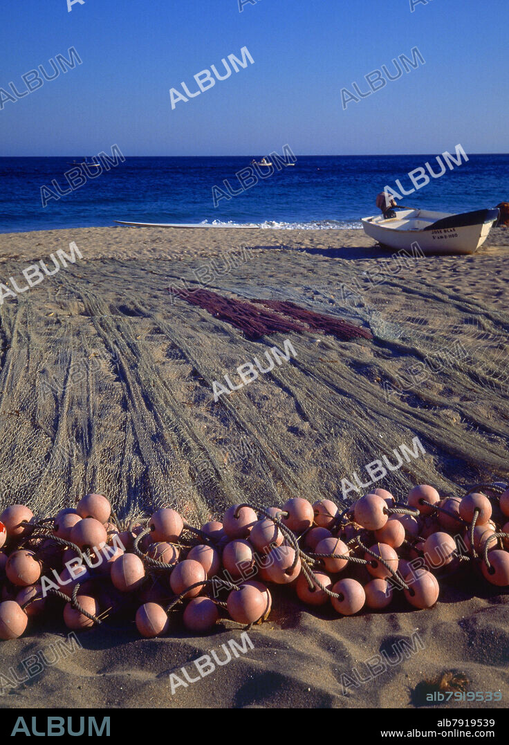 REDES DE PESCA CON BOYAS EN LA PLAYA Y BARCA DE PESCA -.