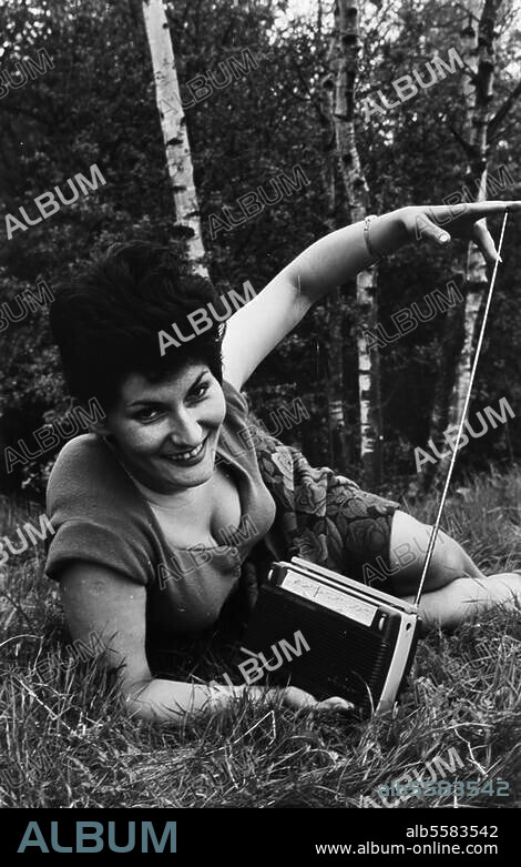 Technology:. Sound Engineering / Radio. Woman with transistor radio on the grass. (Publicity photo for transistor radios by Blaupunkt). Photo, undated (c. 1960?).